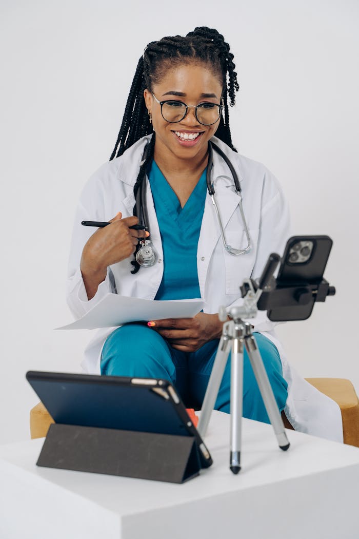 The Art of Drawing Readers In: Your attractive post title goes here Smiling healthcare professional in scrubs using technology for an online consultation.