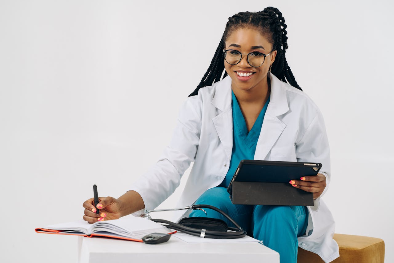 Mastering the First Impression: Your intriguing post title goes here Smiling female doctor in scrubs with tablet and stethoscope, writing notes.